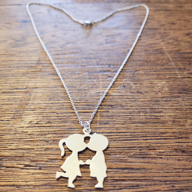 Boy kissing hot sale girl necklace